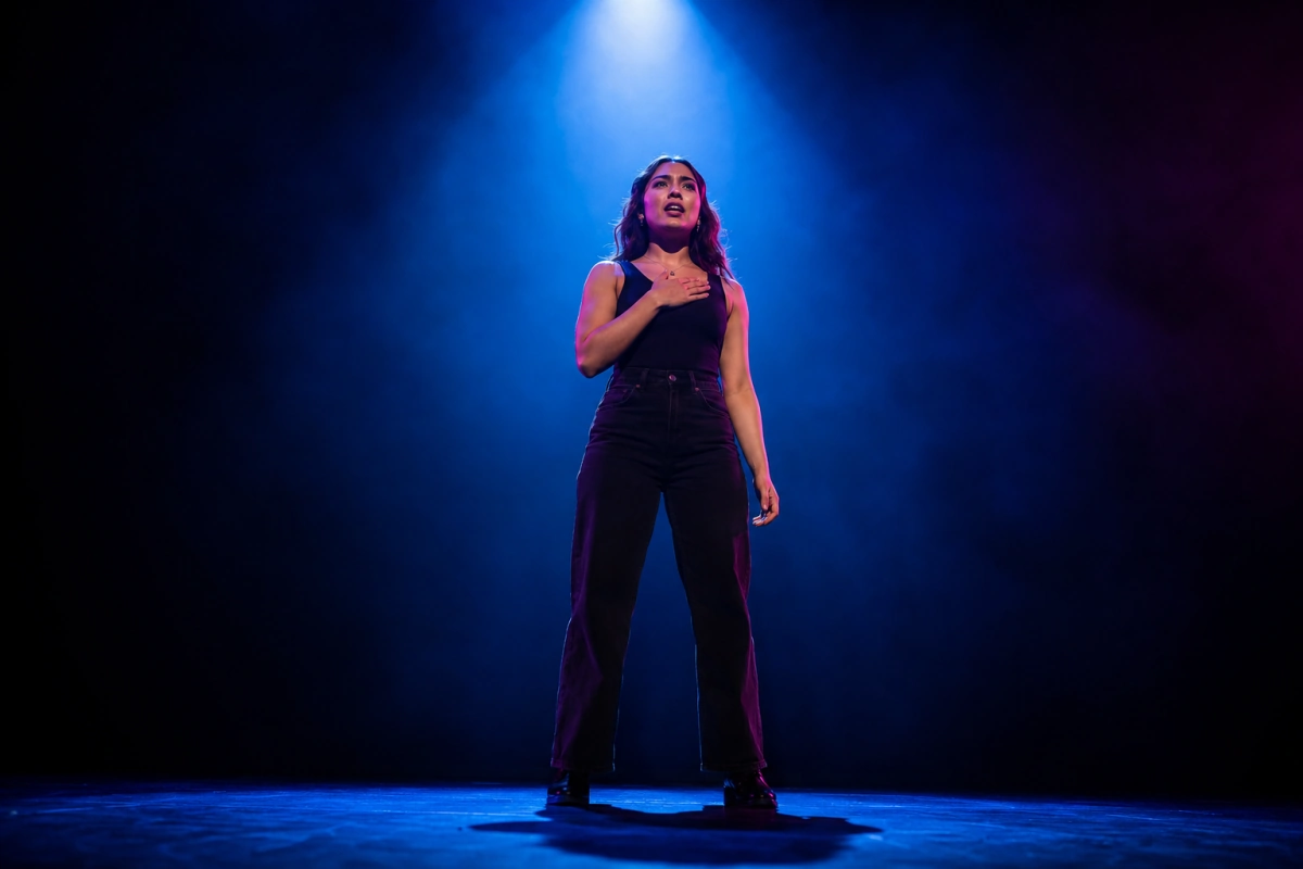 Solo performer under a single spotlight on stage