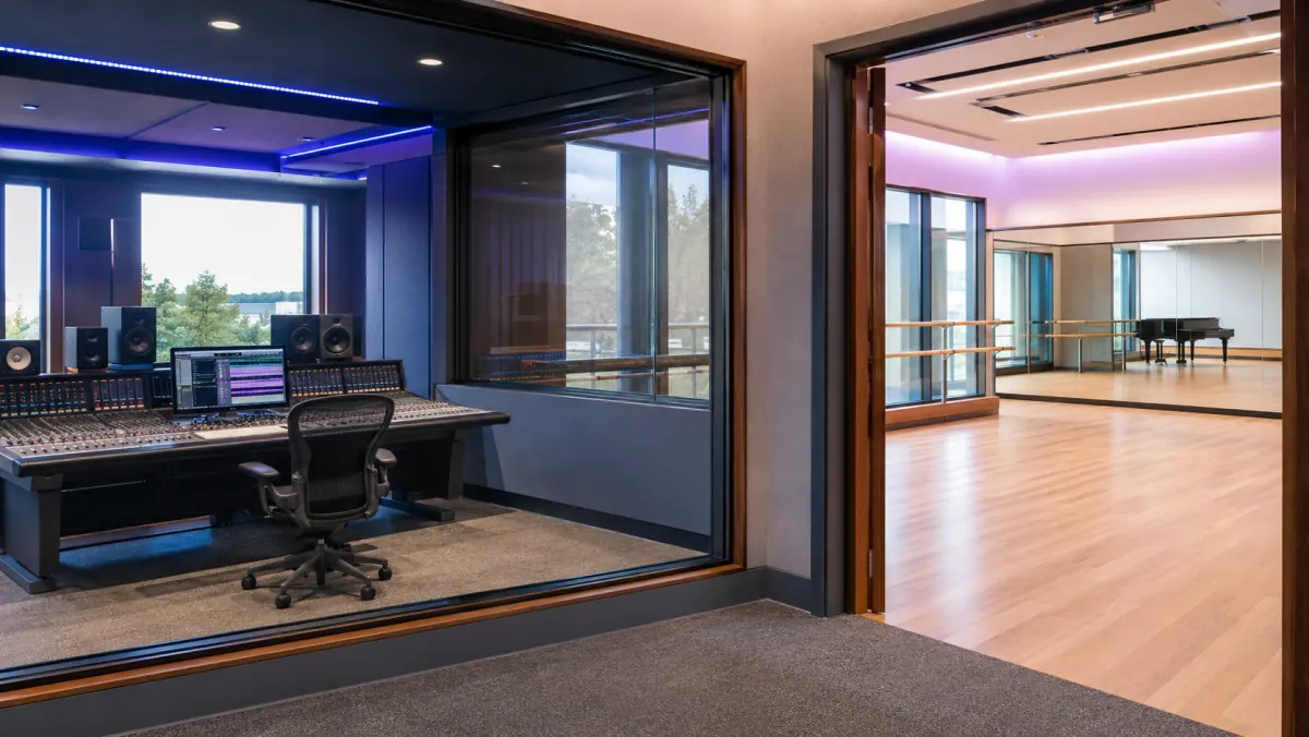 University production facility — control room beside a mirrored dance studio